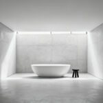 A minimalist bathroom with a pristine white freestanding bathtub against a vast, light concrete wall, emphasizing negative space and visual tranquility.