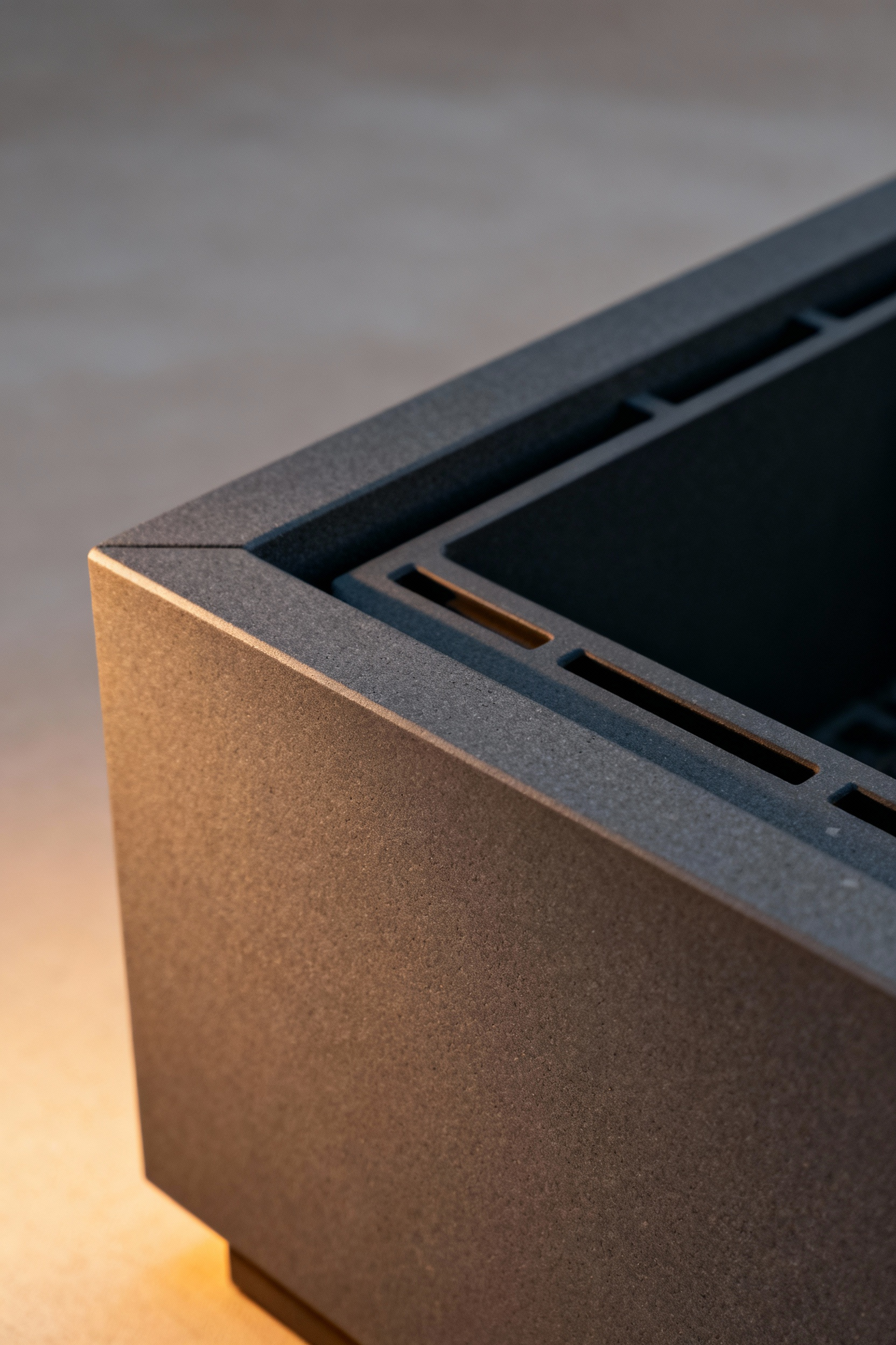 Close-up of a dark grey, smooth advanced ceramic composite liner inside a modern firepit, designed for superior thermal efficiency and long-lasting durability.