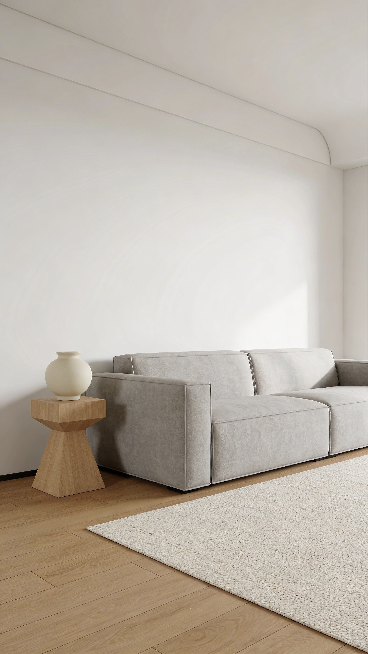 A wide-angle view of a minimalist living room showcasing ample negative space with white walls, a light gray linen sofa, and natural wood flooring, emphasizing organization and visual calmness to reduce cognitive load.