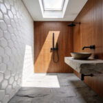 A compact bathroom featuring 3D hexagonal wall tiles and walnut wood accents to illustrate tactile decorating ideas for small spaces.
