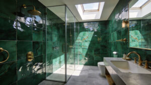 A luxurious bathroom featuring emerald green Zellige wall tiles that catch and scatter natural sunlight to create a shimmering effect.